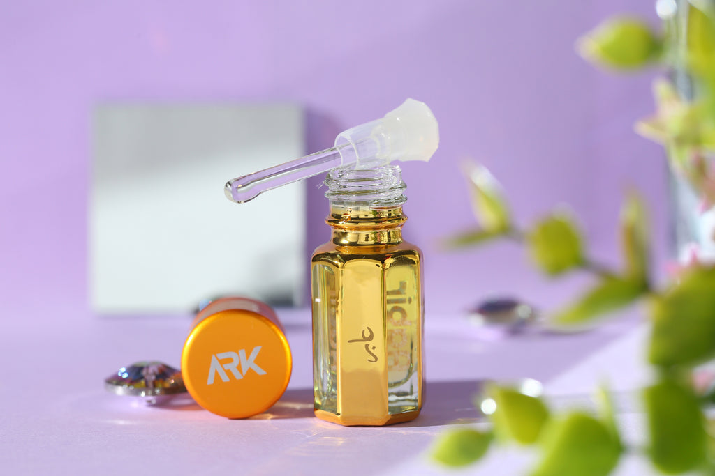 Aabir Attar by ARK Fragrances in gold bottle on purple background. Fresh floral long-lasting perfume oil with crystal applicator. Best sweet musk scent for men and women.