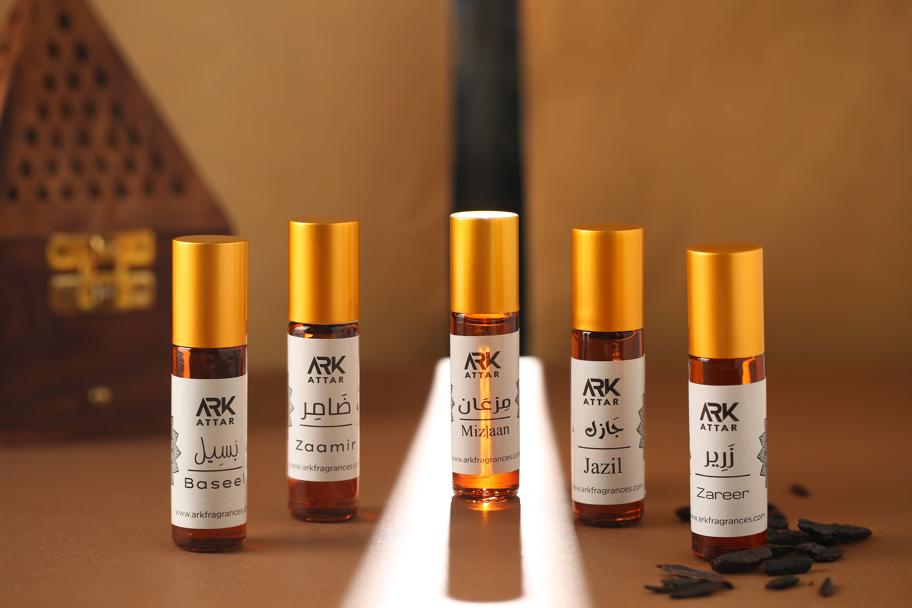Premium Attar Collection by ARK Fragrances featuring Baseel, Zaamir, Mizlaan, Jazil, and Zareer. Set of 5 long-lasting roll-on perfume oils with woody notes. Best Islamic gift set in Pakistan.