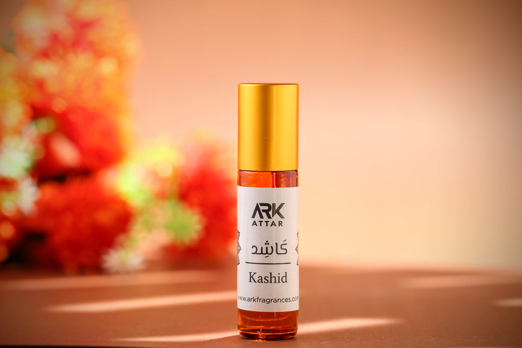 Kashid Attar by ARK Fragrances 6ml premium roll-on perfume oil displayed against a warm floral background. A rich and inviting fragrance featuring a sophisticated blend of Warm Spices, Earthy Woods, and Amber notes. This concentrated, alcohol-free scent is perfect for the Winter season and daily wear. We provide original attar delivery in Karachi, best selling perfume in Lahore, luxury fragrance in Islamabad, and fast shipping to Rawalpindi, Multan, Peshawar, Gujranwala, and nationwide across Pakistan.