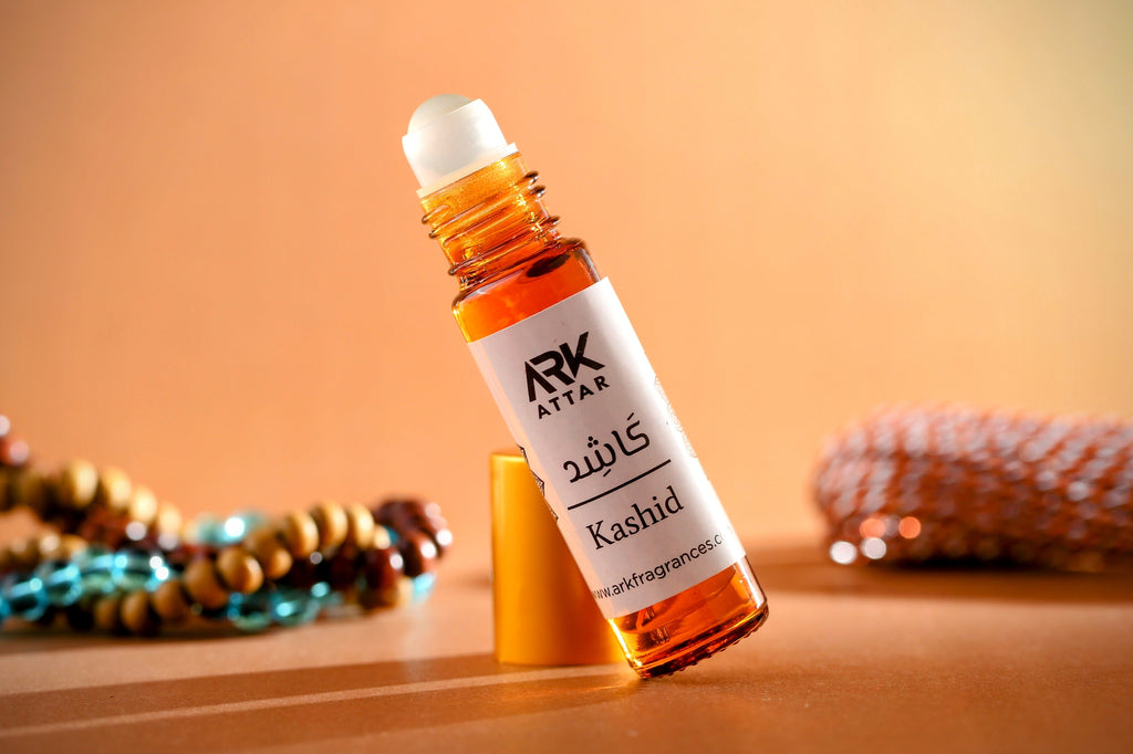 Kashid Attar by ARK Fragrances 6ml premium roll-on perfume oil displayed with elegant beads on a warm brown background. A rich and inviting winter fragrance featuring deep notes of Warm Spices, Earthy Woods, and Amber. This long-lasting, alcohol-free scent is perfect for both men and women. We offer original attar delivery in Karachi, best selling perfume in Lahore, luxury fragrance in Islamabad, and fast shipping to Rawalpindi, Multan, Peshawar, Gujranwala, and nationwide across Pakistan.