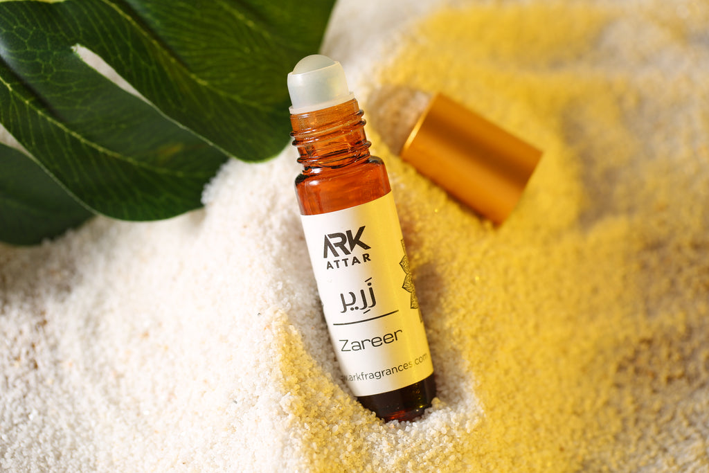 Zareer Attar by ARK Fragrances 6ml roll on perfume oil displayed on white sand with green leaf fresh scent online delivery in Lahore Karachi Islamabad Faisalabad and Pakistan
