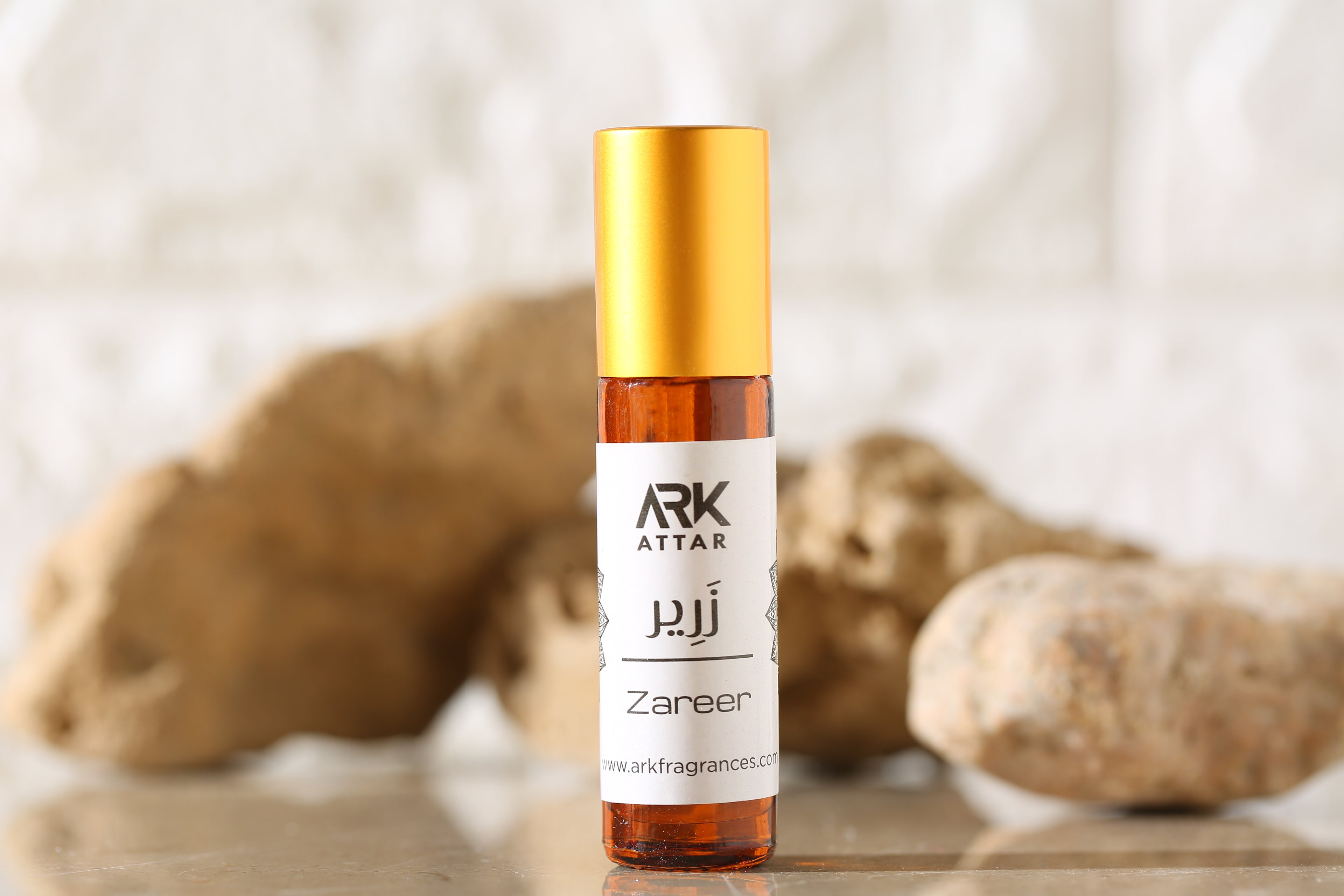 Zareer Attar by ARK Fragrances 6ml roll on perfume oil displayed on rocks with earthy background best natural scent online delivery in Lahore Karachi Islamabad Rawalpindi Multan Peshawar Gujranwala Hyderabad Sialkot Quetta and Pakistan