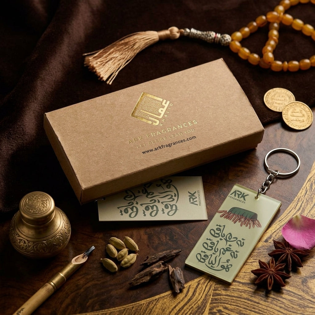 Premium acrylic calligraphy keychain with traditional earthy green design, placed next to a luxury ARK Fragrances kraft gift box, tasbeeh, and calligraphy pen.